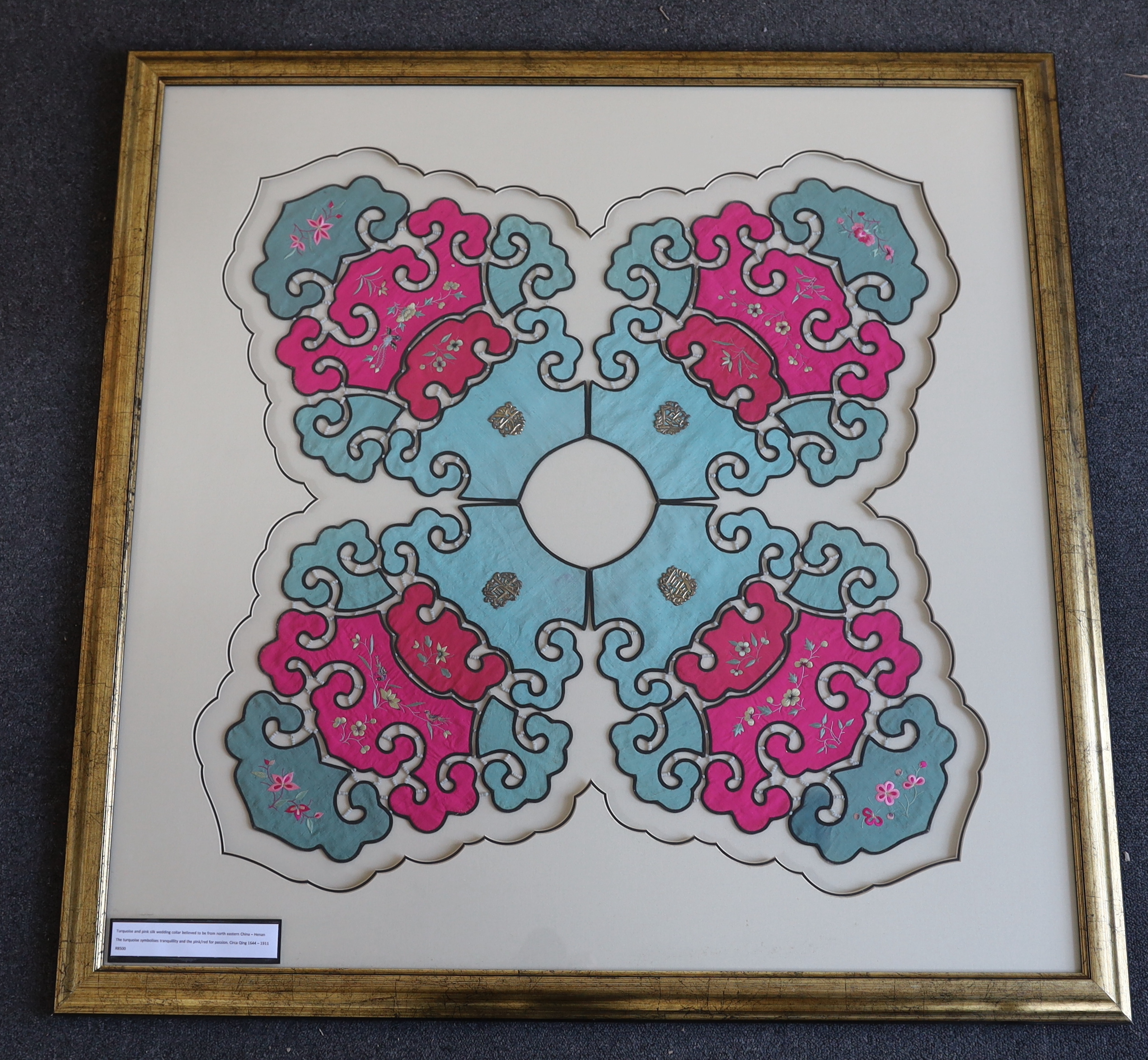 A large early 20th century Chinese intricately shaped collar, made of pink and turquoise silk, embroidered with polychrome birds and flowers, attached together with white beading and decorated with four white metal attac